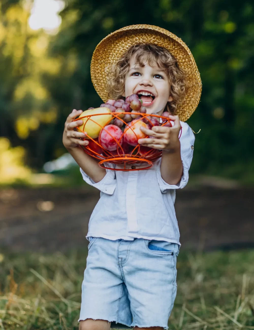little-boy-with-grapes-forest-picnic-scaled-1.webp